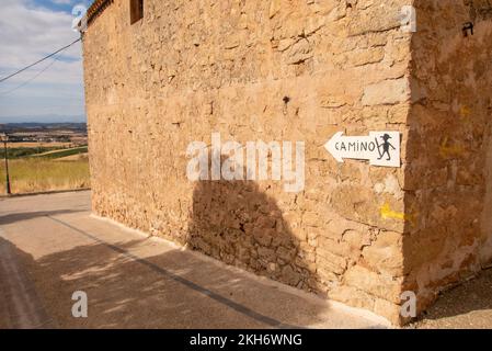 Nach Santiago, hier entlang. Eine Markierung für Pilger auf dem Camino de Santiago an einer Mauer im Dorf Monjardin. Stockfoto