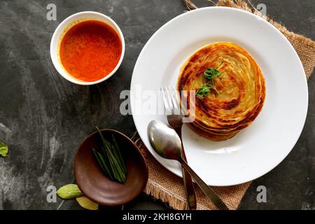 Paratha-Brot oder Canai-Brot oder Rotwein maryam, Lieblingsfrühstück. Serviert auf dem Teller Stockfoto