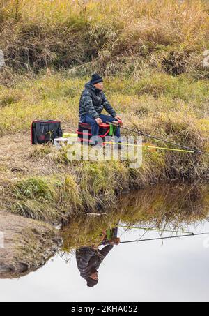 Ein Mann, der vom Ufer aus auf einem See angeln will. Mann zum Entspannen und Angeln am See in British Columbia, Kanada - November 21,2022. Pitt Lake. Reisefoto Stockfoto