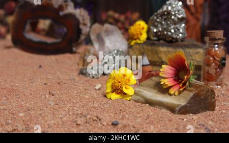 Gelbe Blumen mit Pyritfelsen und Kristallen auf dem australischen roten Sand Stockfoto