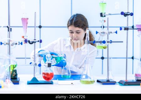 Junge Erwachsene Wissenschaftlerin führt ein chemisches Experiment in einem Kohlenwasserstoffsyntheselabor durch Stockfoto