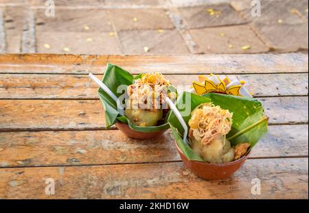 Zwei nicaraguanische Vigorones, serviert auf Holz. Das Vigoron-typische Essen von Granada, Nicaragua, traditionelles Vigoron in Bananenblättern, serviert auf einem Holztisch Stockfoto