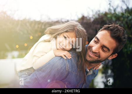 Daddy-Hingabe. Ein kleines Mädchen und ihr Vater, die draußen zusammen spielen. Stockfoto