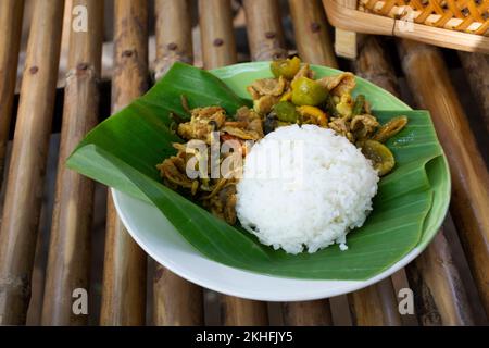 Traditionelle thailändische Küche, scharfe, in Rührei gebratene Wildschweine und gelbes Gewürz, Curry, Schweinefleisch, Gemüsegarnierung auf gekochtem Reis auf Bananenblatt im oh poi lo Stockfoto