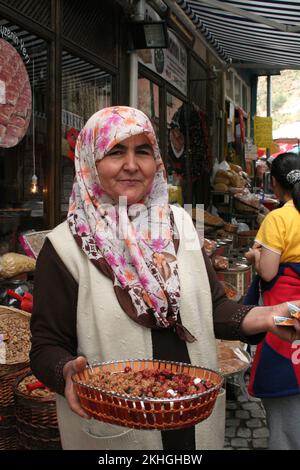 Frau, die Trockenfrüchte anbietet, Straßenszene, Haupteinkaufsstraße, Beypazari, Türkei. Stockfoto