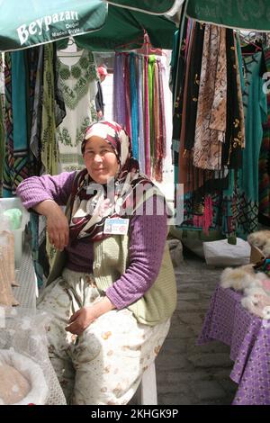 Straßenszene, Frau in traditioneller türkischer Kleidung, serviert an der Kleiderbude in der Haupteinkaufsstraße Beypazari, Türkei Stockfoto