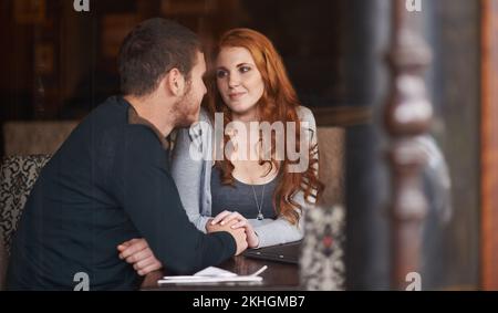 In den Augen des anderen verloren. Ein junges, liebevolles Paar auf einem Kaffee-Date. Stockfoto