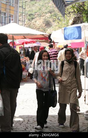 Straßenszene; Haupteinkaufsstraße; Beypazari; Türkei; zwei quatschende Frauen, eine mit Kopftuch und die andere ohne, Stockfoto