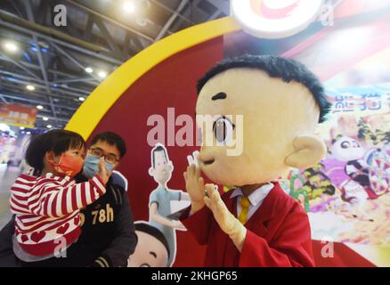 HANGZHOU, CHINA - 24. NOVEMBER 2022 - Kinder interagieren mit der Zeichentrickfigur „Big Head Son“ auf dem China International Cartoon and Animation Festiva Stockfoto