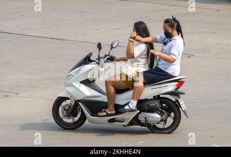 SAMUT PRAKAN, THAILAND, 02 2022. MÄRZ, zwei Frauen fahren auf dem Motorrad auf der Straße. Stockfoto