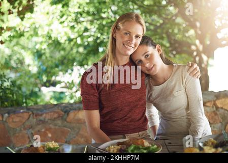 Zeit für die Familie. Abgeschnittenes Porträt einer Frau und ihrer Tochter, die ein Familienessen im Freien genießen. Stockfoto