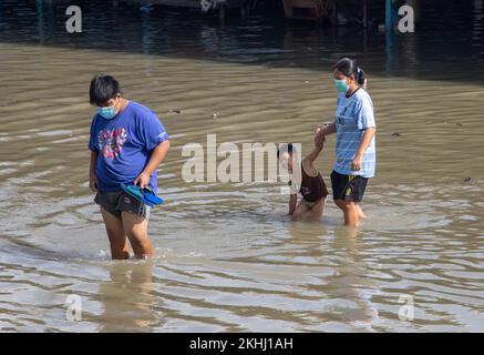 SAMUT PRAKAN, THAILAND, Okt 29 2022, Eine Familie mit einem Kind geht entlang einer überfluteten Straße Stockfoto