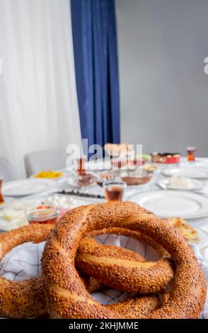 Türkischer Bagel heißt Simit, Nahaufnahme, selektiver Fokus auf türkischen Bagel namens Simit. Verschwommener Hintergrund für den Frühstückstisch. Stockfoto