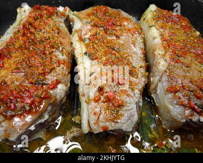 Drei geröstete Rindersteaks mit Gewürzen in einem Topf. Stockfoto
