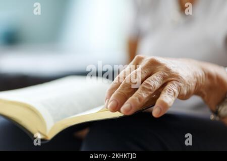 Nahaufnahme der Hände der Seniorin auf der bibel, gefaltet im Gebet Stockfoto