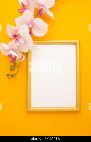 Goldener Rahmen auf gelbem Hintergrund mit Orchidee mit Platz für Text. Hochwertiges Foto Stockfoto