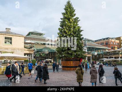 Menschen in Covent Garden. Riesige dekorierte Weihnachtsbaumständer auf der Piazza. London, England, Großbritannien Stockfoto