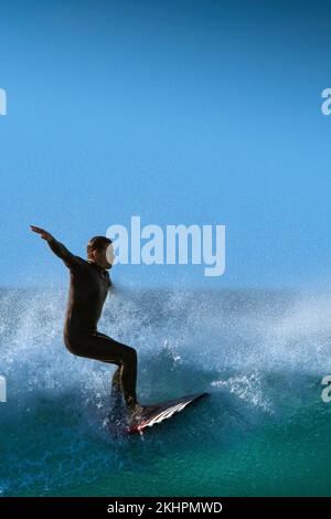 Spektakuläre Surfaktion als männlicher Surfer reitet auf einer Welle im Fistral in Newquay in Cornwall in England in Großbritannien. Stockfoto