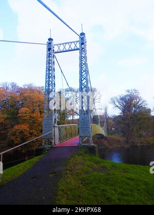 Ein 2022-Grad-Blick auf Penkiln Suspension Bridge, Minnigaff (Dumfries und Galloway, Schottland), auch bekannt als King George V Suspension Bridge, Newton Stewart D & G. Minnigaff. Erbaut 1911 von D H und F Reid, Victoria Works, Ayr, Ingenieure. Eine leichte Gittertraverse, die von Drahtseilseilen durch Stahlstangenhalter gestützt wird. Die Pylonen sind auch aus Gittern gebaut. Der Fluss bildet die Grenze zwischen den Gemeinden Minnigaff und Penninghame. Es wurde in den 22/6/1911 errichtet und ist aus Guss und Schmiedeeisen gebaut. Größere strukturelle Reparaturen 1982 von Craich und Hogg, Ingenieuren, W & J Barr Vertragspartnern Stockfoto