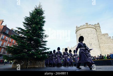 Mitglieder der Nijmegen Company Grenadier Guards gehen an einem Weihnachtsbaum außerhalb von Windsor Castle vorbei, während sie am Wachwechsel in Windsor Castle, Berkshire, teilnehmen. Foto: Donnerstag, 24. November 2022. Stockfoto