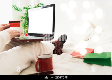 Online-Shopping-Konzept mit Frau mit Laptop und Kreditkarte Zu Hause Stockfoto