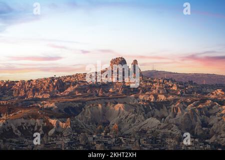 Atemberaubender Blick auf das Dorf Goreme mit dem Uchisar Castle in der Ferne während eines wunderschönen Sonnenaufgangs. Kappadokien, Zentralantolia, Türkei. Stockfoto