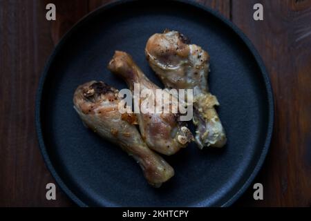Gegrillte Hähnchenkeulen mit Gewürzen und Knoblauch. Ansicht von oben Stockfoto