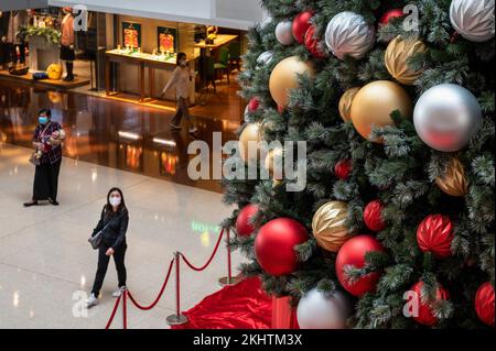 Hongkong, China. 16.. November 2022. Einkaufslustige gehen in einem Einkaufszentrum in Hongkong an der Installation von Weihnachtsbäumen vorbei. (Foto: Miguel Candela/SOPA Images/Sipa USA) Guthaben: SIPA USA/Alamy Live News Stockfoto