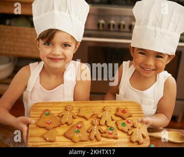 Porträt, Mädchen und Weihnachtskekse in der Küche, Lächeln und fröhlich für Weihnachten, Urlaub und Freude. Weihnachten, Freundinnen und Backspezialitäten zusammen, für Stockfoto