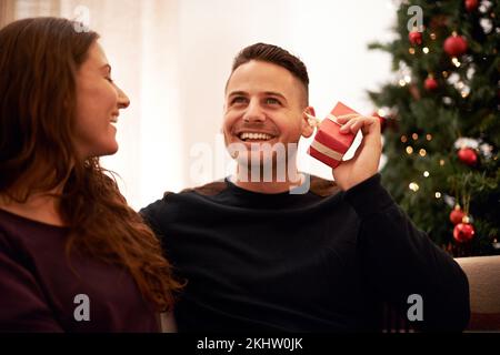 Paare, Christmas and love mit Guess Geschenkbox für Überraschung, Glück und Weihnachtsfreude. Glücklich, verheiratet und präsent für Partner, der rät, was Stockfoto