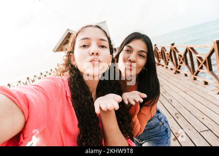 Die beiden hispanischen Freunde, die einen Kuss blasen und ein Foto an einem touristischen Ort in Honduras machen Stockfoto