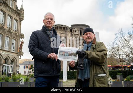 Trier, Deutschland. 24.. November 2022. Trier-Künstler Clas Steinmann (r) und Trier-Bürgermeister Wolfram Leibe (SPD) stehen mit einem Plan auf dem Gelände der geplanten Gedenkstätte (Porta Nigra Square) für diejenigen, die bei einem Amoklauf am 1. Dezember 2020 getötet wurden. Die Gedenksteine sollen im kommenden Jahr an diesem Standort errichtet werden. Kredit: Harald Tittel/dpa/Alamy Live News Stockfoto