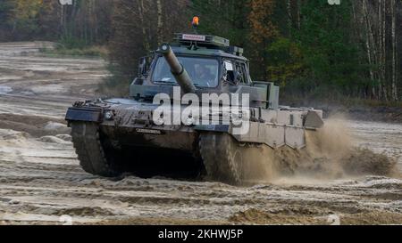 Munster, Deutschland. 24.. November 2022. Ein slowakischer Soldat fährt während des Fahrtrainings einen Fahrtrainingspanzer der Bundeswehr Leopard II durch das Gelände. Die Bundeswehr trainiert derzeit slowakische Soldaten auf dem Leopard 2 A4 Hauptpanzer in Munster. Hintergrund ist ein Ringaustausch von 15 Leopardenpanzern in die Slowakei, der von der deutschen Regierung in Auftrag gegeben wurde, wie die Bundeswehr am Donnerstag angekündigt hat. Kredit: Philipp Schulze/dpa/Alamy Live News Stockfoto