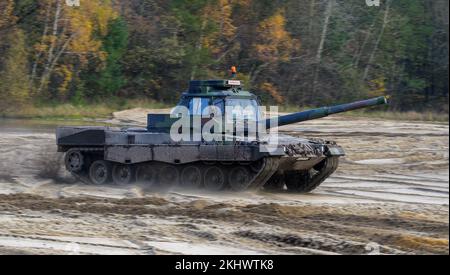 Munster, Deutschland. 24.. November 2022. Ein slowakischer Soldat fährt während des Fahrtrainings einen Fahrtrainingspanzer der Bundeswehr Leopard II durch das Gelände. Die Bundeswehr trainiert derzeit slowakische Soldaten auf dem Leopard 2 A4 Hauptpanzer in Munster. Hintergrund ist ein Ringaustausch von 15 Leopardenpanzern in die Slowakei, der von der deutschen Regierung in Auftrag gegeben wurde, wie die Bundeswehr am Donnerstag angekündigt hat. Kredit: Philipp Schulze/dpa/Alamy Live News Stockfoto