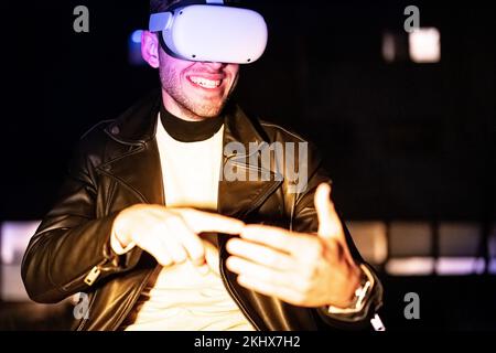 Junger Hacker, der eine Videobrille verwendet, um im Deep Web zu surfen und heimlich vor den Behörden zu handeln, Gesten auf virtuellem Pad, erweiterter Realität und Meta zu machen Stockfoto