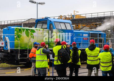 24. November 2022, Sachsen-Anhalt, Stendal: Medienvertreter und Mitarbeiter von Alstom stehen vor einer wasserstoffbetriebenen Rangierlokomotive, aus der Dampf steigt. Das Unternehmen sieht ein beträchtliches Potenzial bei der Umstellung von dieselbetriebenen Rangierlokomotiven auf Wasserstoffantrieb. In Deutschland sind etwa 1000 Diesel-Rangierlokomotiven in Betrieb und in ganz Europa etwa 4000. Bisher wurden Hybridlokomotiven mit Batterie- und Dieselantrieb betrieben; in Zukunft werden sie mit Batterie- und Wasserstoffantrieb betrieben. Eine Lokomotive emittiert etwa 150 Tonnen CO2 pro Jahr Stockfoto