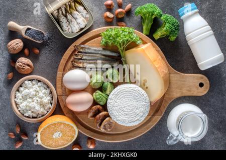 Osteoporose-Konzept. Für Osteoporose empfohlene Lebensmittel, kalziumreiche und nicht kalziumreiche Tagebücher. Stockfoto