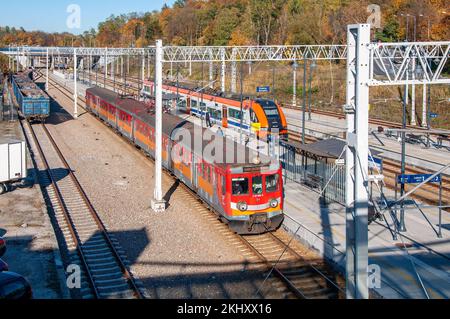 Kraków, Polen - 20. Oktober 2022: Zwei Züge, ein alter und ein moderner für schnelle Stadt- und Regionalverkehrsverbindungen auf Kraków-Bonarka, neu gebaut Stockfoto