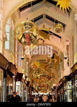 Burlington Arcade mit Weihnachtsdekorationen, ein ikonisches Luxus-Einkaufszentrum bei Piccadilly, London. Käufer mit einer Frau, die ein Foto macht. Stockfoto