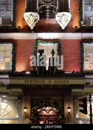 Die Fassade des Fortnum und Mason Department Store zeigt die berühmten Symbole des Geschäfts, Piccadilly London. Stockfoto