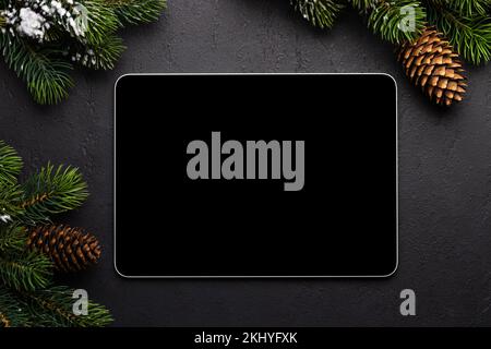 Tablet mit leerem Bildschirm und weihnachtlicher Einrichtung. Vorlage für den Bildschirm des Weihnachtsgeräts Stockfoto