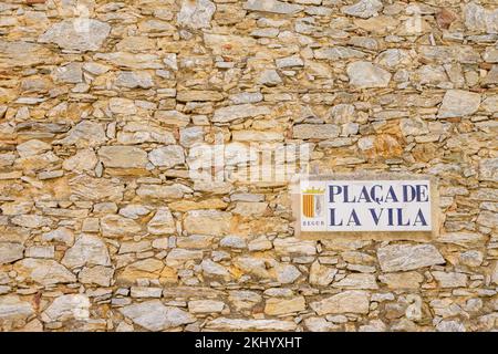 Schild Placa de La Vila an der alten Steinmauer im Zentrum von Begur Catalunya Spanien Stockfoto
