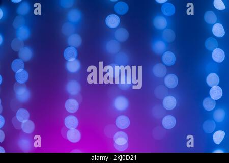 Weihnachtliches blaues Bokeh aus Girlande-Neonlicht. Bokeh-Lichter. Wunderschöner Weihnachtshintergrund. Desfokussierter Hintergrund. Bereichstext kopieren. Konzept verschwommenes Blau Weihnachtsdekorationen Girlanden Lichter Bokeh Stockfoto
