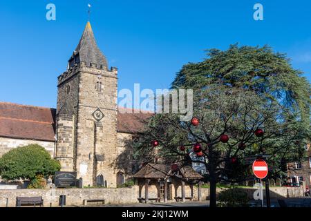 St Mary Magdalene & St Denys Church in Midhurst, West Sussex, England, Großbritannien, mit einem Baum auf dem Marktplatz, dekoriert mit roten Kugeln zu Weihnachten Stockfoto