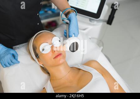 Mittelgroße Nahaufnahme einer Weißen, die sich einem nicht chirurgischen Gesichtsheben im kosmetologischen Zentrum unterzieht, Gesichtsbehandlung. Hochwertiges Foto Stockfoto