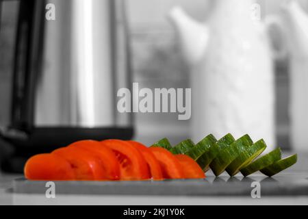 Frisch geschnittene Tomaten und geschnittene ​​cucumbers auf weißem Hintergrund schwarz-weiß . Selektiver Fokus. Stockfoto