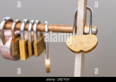 Liebesschlösser hängen im Herbst an der Brücke. Konzept von Liebe, Ehe und Paaren. Herzförmiges Vorhängeschloss. Stockfoto