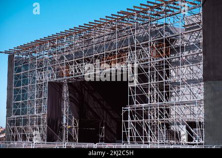 Installation von professionellen Konzertgeräten. Anheben von Line-Array-Lautsprechern. Eine Dachrinne mit Scheinwerferlampen über der Bühne. Stockfoto