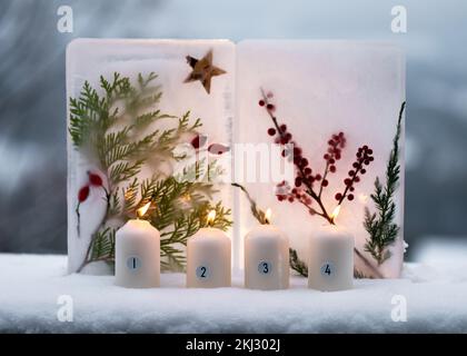 Weihnachten, Adventskranz mit vier weißen brennenden Kerzen, dekoriert mit Metallnummern und zwei Eislaternen dahinter. Gartendekoration im Freien. Stockfoto