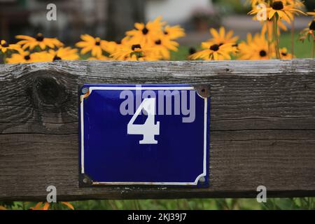 Schild Nummer vier auf einer Holzzaunplatte Stockfoto